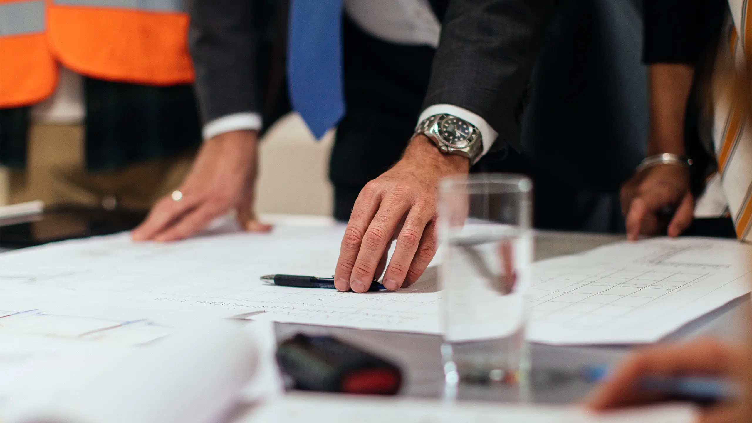 Man in suit leaning over architectural plans