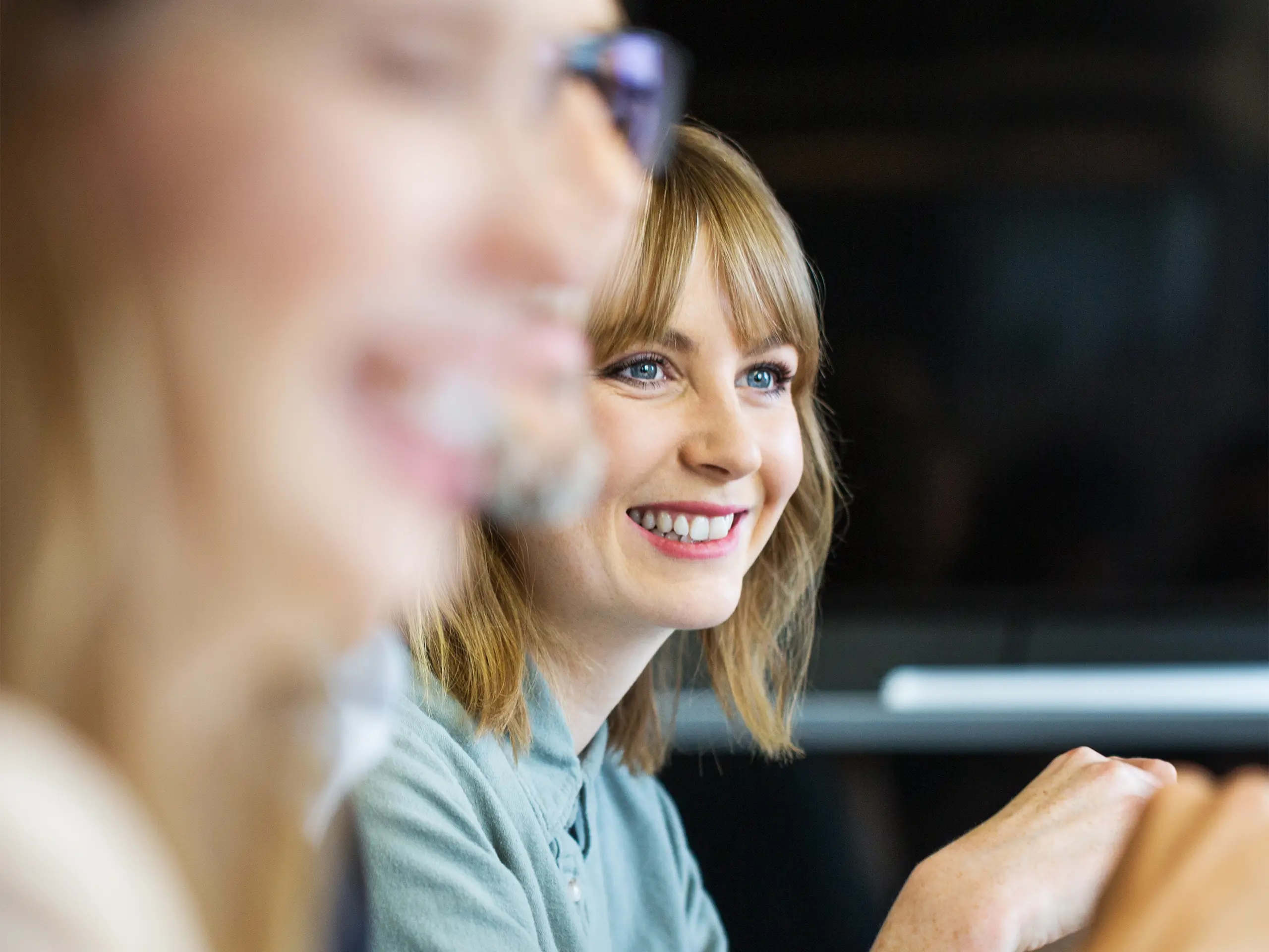 Female professional listening to colleague in meeting.